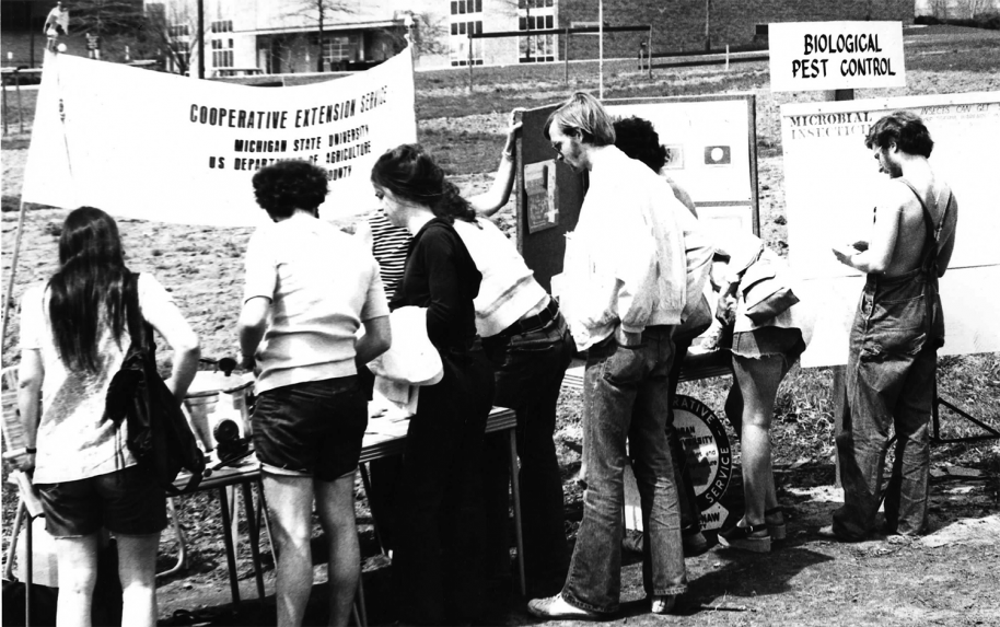 A group of people gather around a table at an outdoor event