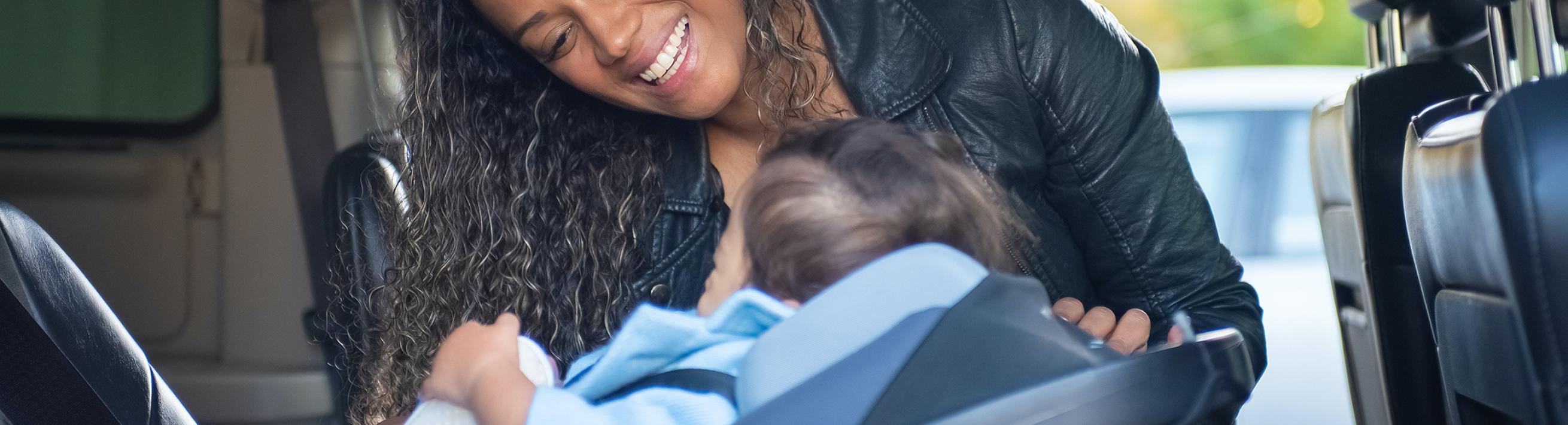 woman buckling child into carseat