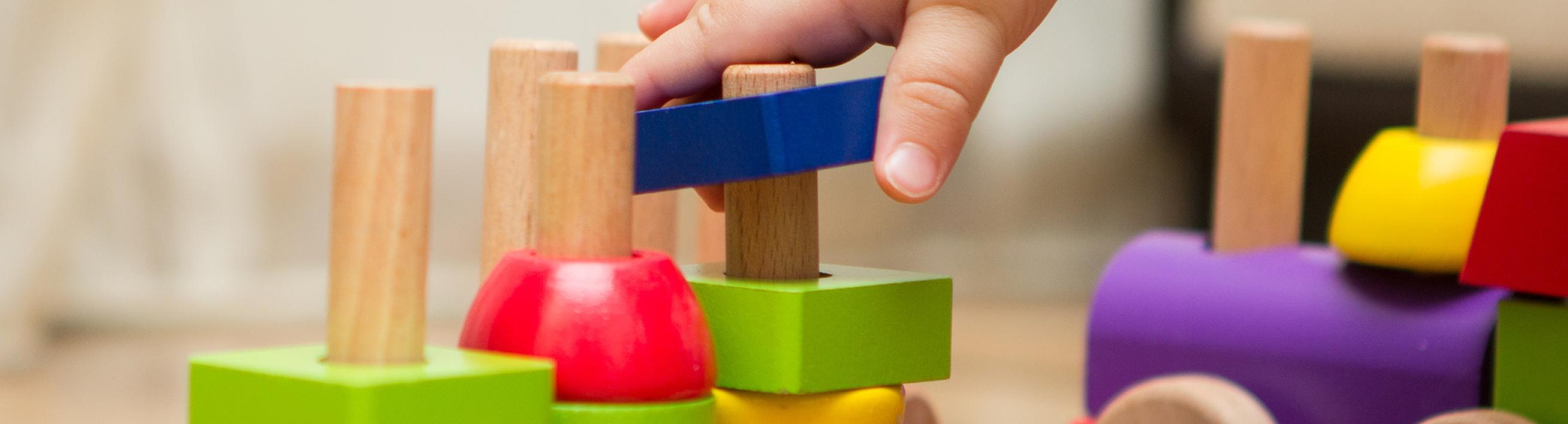 A baby's hand touches toys