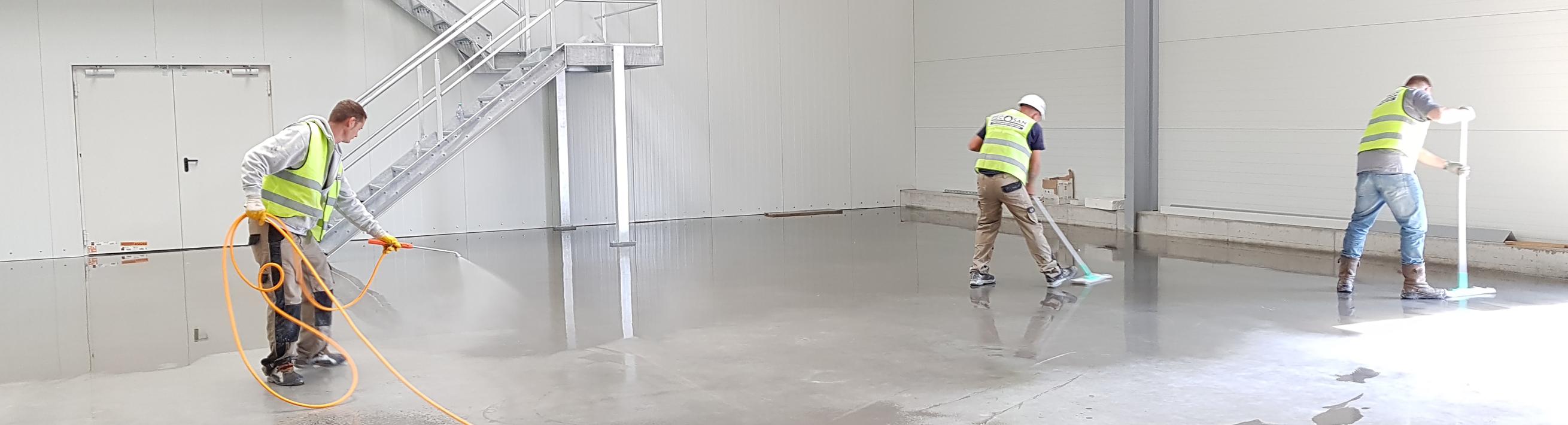 Three workers cleaning an open room