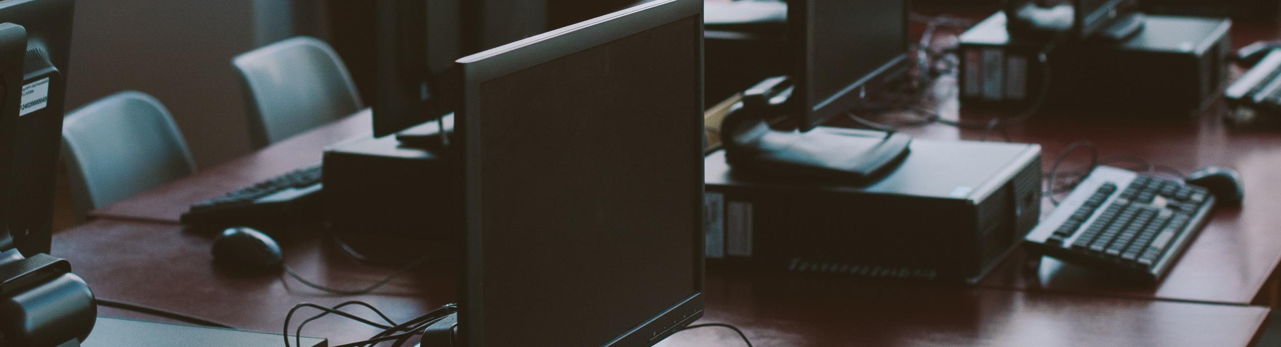 Computer monitors and keyboards together on a desk