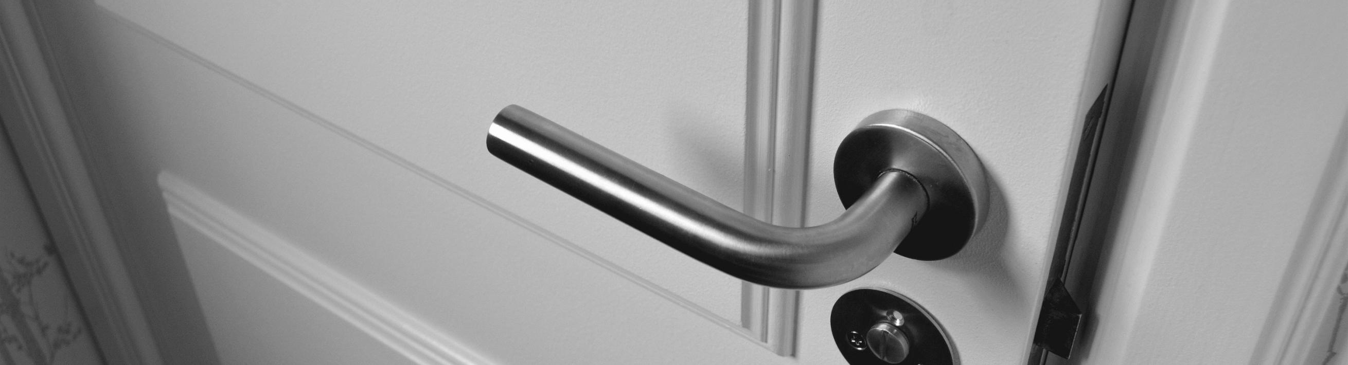A handle and lock on a white door