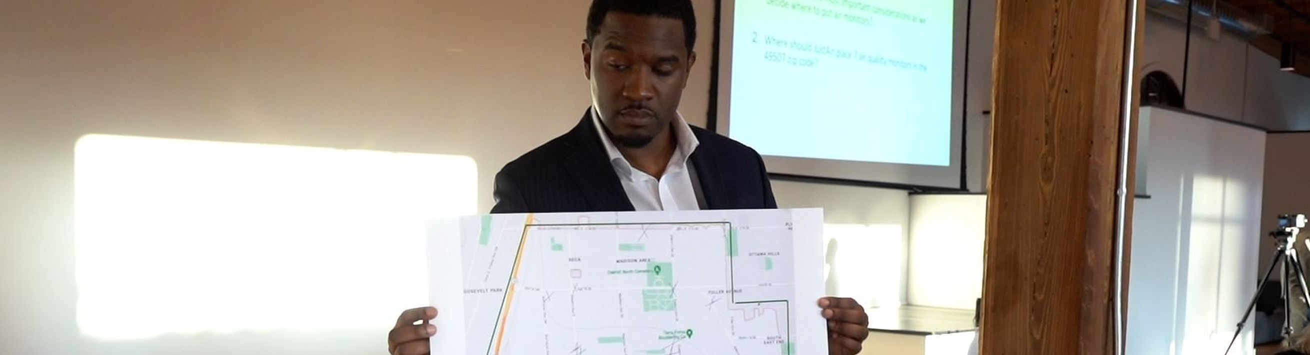 Man holds poster at a meeting