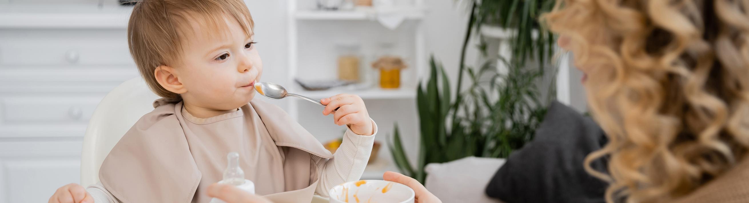 Baby eating baby food with a spoon