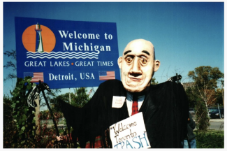 A dummy of Governor John Engler in front of a Welcome to Michigan sign
